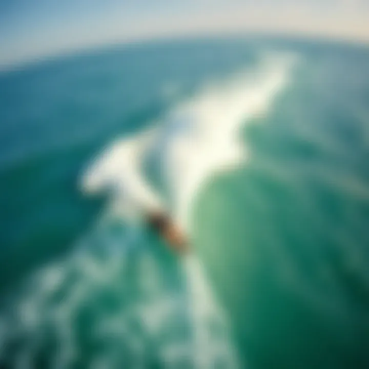 Riding the Waves While Kiteboarding An aerial view of a kiteboarder gracefully riding the waves