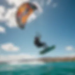 A kiteboarder gliding over turquoise waters with vibrant kite in the sky
