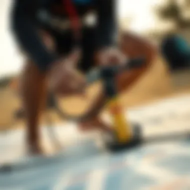 Kiteboarder preparing equipment with pump on the beach