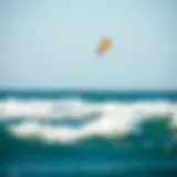 A vibrant kite soaring high above the ocean waves